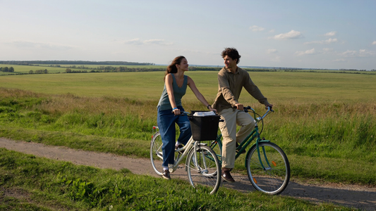 Twee vrienden van begin dertig fietsen naast elkaar over een dijk in de late middagzon